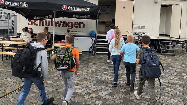 Schüler*innen auf dem Weg in den Schulwagen